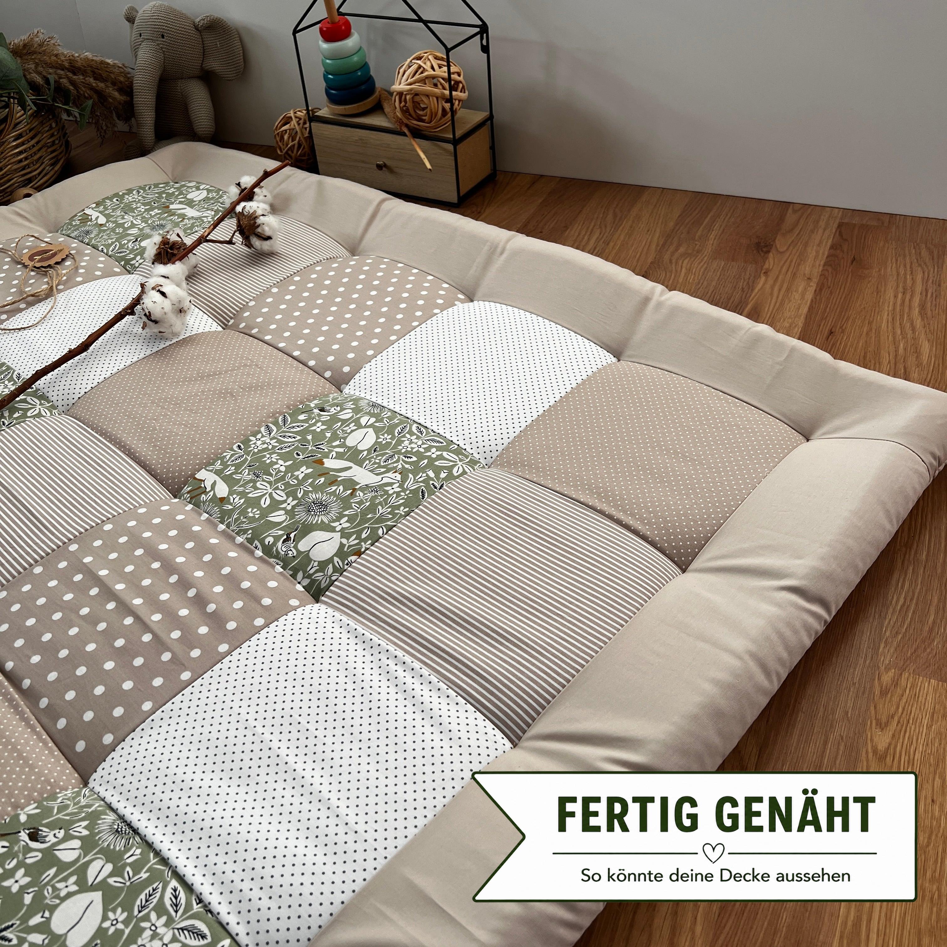 a patchwork quilt or mat with a variety of colors and patterns, including polka dots, stripes, and floral designs, laid out on a wooden floor.
