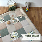 a patchwork quilt with a variety of colorful squares, a stuffed elephant toy, and some decorative elements such as a potted plant and a woven basket.