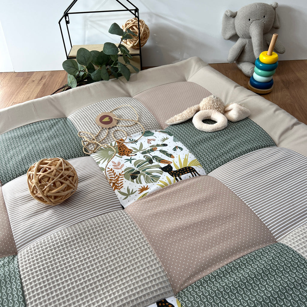 a cozy and colorful baby's room with a quilt-like bedspread, a stuffed elephant toy, and various decorative elements such as a woven ball, a potted plant, and a stack of rings.