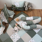 a cozy and inviting nursery setting with a quilt, stuffed animals, and a basket.